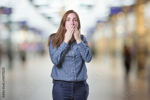 Pretty business woman covering her mouth over blur background