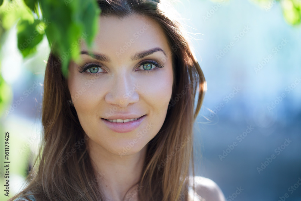 Close-up portrait of a beautiful woman, brunette. On a background summer nature Close-up portrait of a beautiful woman, brunette. On a background summer nature