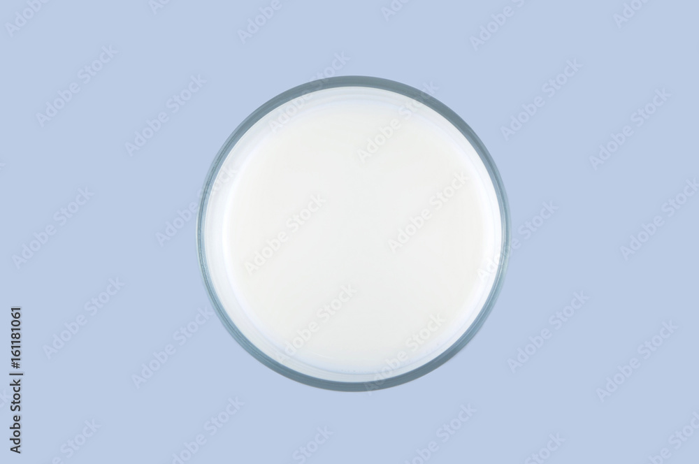 Top view of a glass of milk isolated on the light blue background Top view of a glass of milk isolated on the light blue background