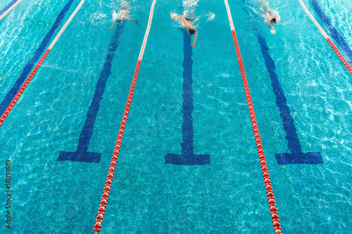 Three male swimmers racing against each other