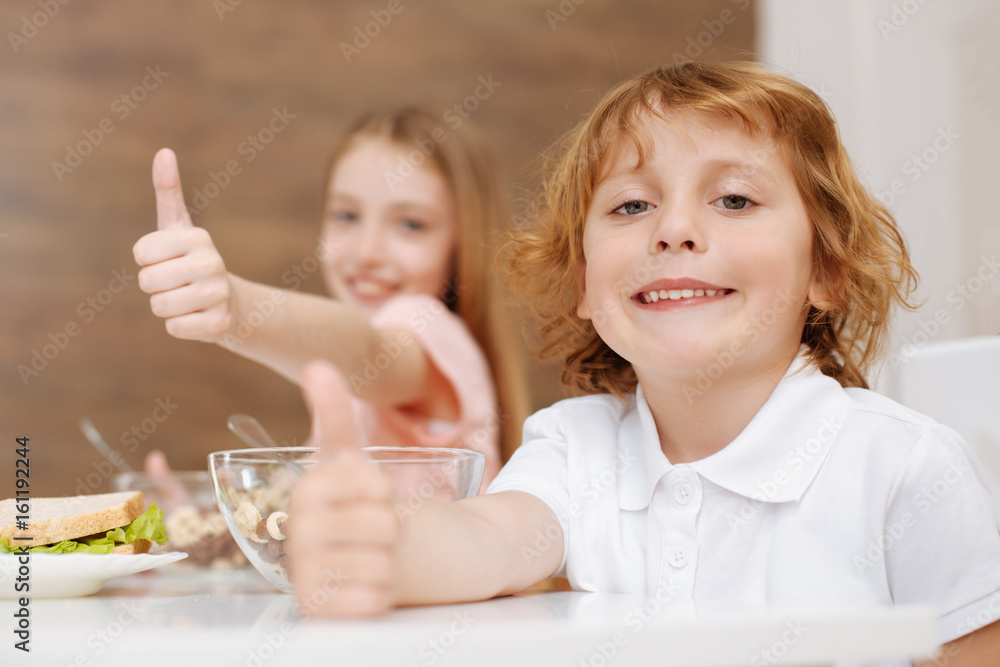 Adorable smiley boy enjoying breakfast with his sister Adorable smiley boy enjoying breakfast with his sister