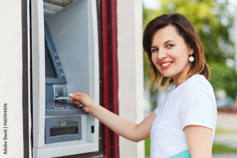 Young beautiful woman using an ATM Young beautiful woman using an ATM