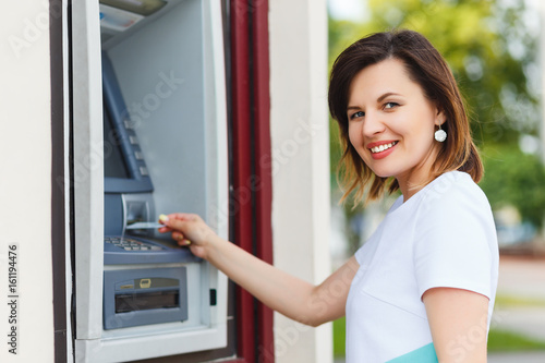 Young beautiful woman using an ATM
