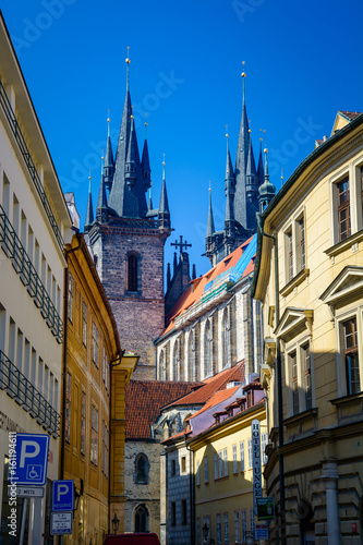 The Church of our Lady before Tyn from an intersting perspective as seen from a sidewalk with colorful buildings on both sides. Prague, Czech Republic