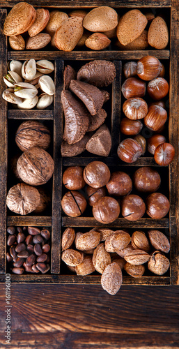 Nuts Mixed in a Wooden Vintage Box.Assortment, Walnuts,Pecan,Peanuts,Almonds,Hazelnuts,Macadamia,Cashews,Pistachios.Concept of Healthy Eating.Vegetarian.selective focus.