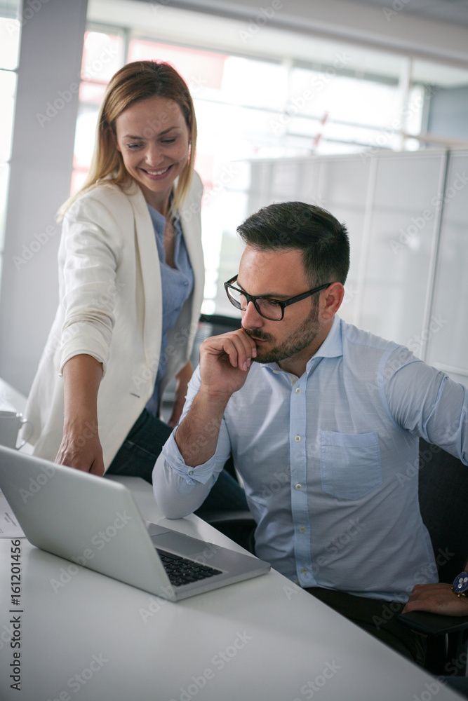 Two business people watching something on laptop. Business woman showing something to colleague in laptop. Two business people watching something on laptop. Business woman showing something to colleague in laptop.