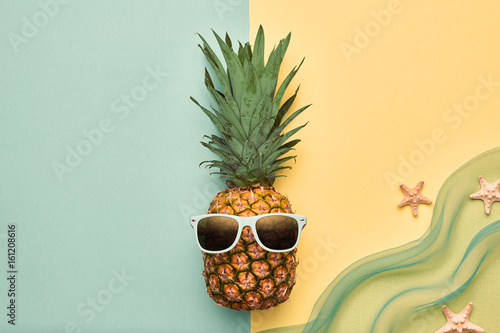 Fashion Hipster Pineapple Fruit. Bright Summer Color, Accessories. Tropical pineapple with Sunglasses. Creative Art concept. Minimal style. Summer party Yellow background