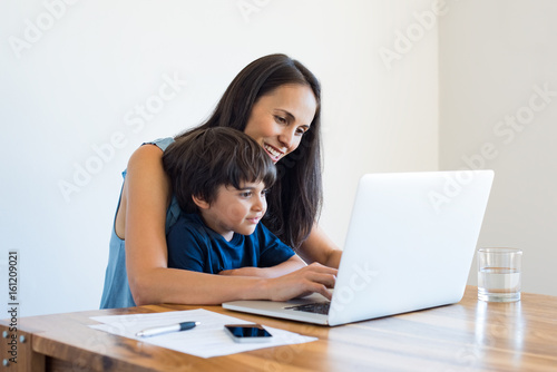 Mother working at home with son