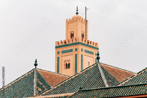 traditional moroccan minaret behind roofs photo