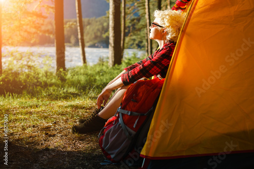 Woman sitting in a tent enjoying the rays of the sun.