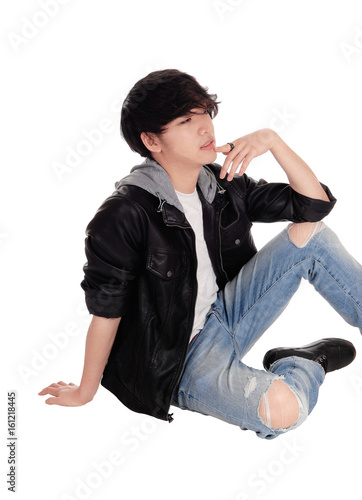 Young Asian man sitting on floor.