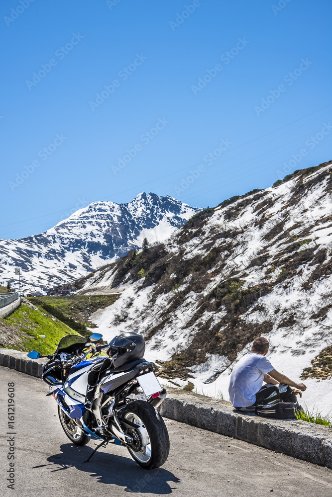 Fototapeta premium motard sur parking dans les alpes