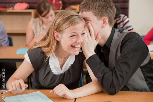 Two students share a secret in class photo