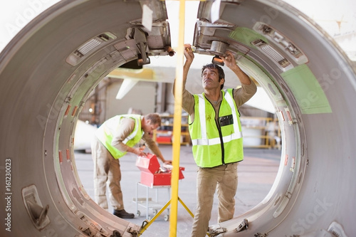 Aircraft workers checking airplane part photo