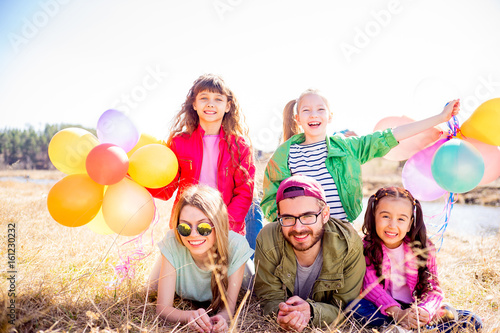 Family lying on grass with balloons