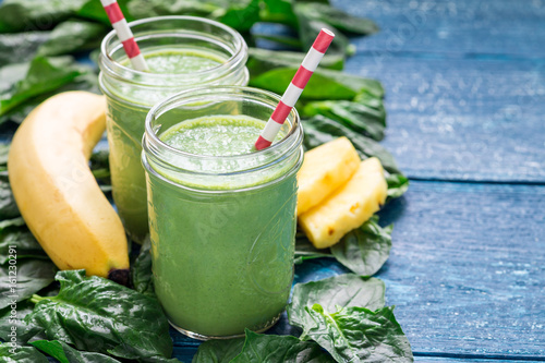 Detox green smoothie with spinach, pineapple, banana and yogurt, copy space