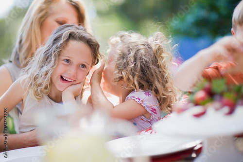 Smiling girls whispering outdoors