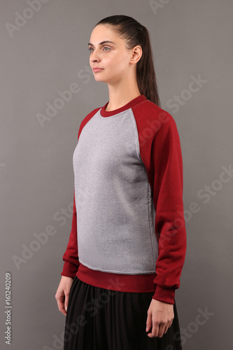 Young hipster girl wearing blank grey and burgundy cotton sweatshirt with crew neck and raglan sleeves with copy space for your design or logo, mock-up of ltemplate womens hoodie photo