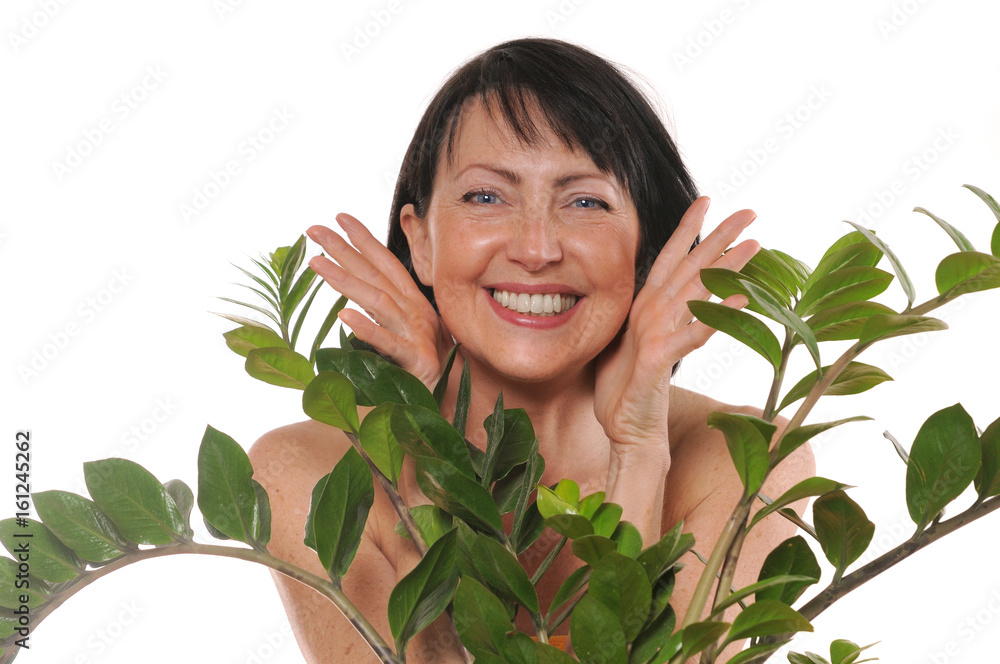 Cheerful happy mature woman peep out from behind the flowers Cheerful happy mature woman peep out from behind the flowers