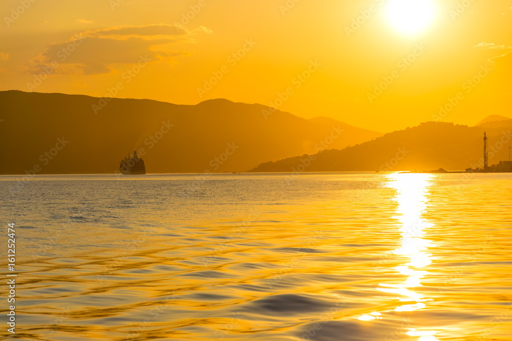 A large liner sails in the rays of the sunset along the Boka-Kotorska Bay. Montenegro.
