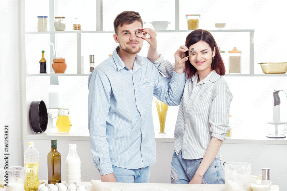 Fototapeta premium Funny Couple in love cooking dough and having fun with flour in kitchen