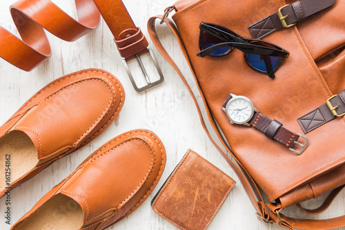 Foto Men's leather accessories on white rustic wooden background