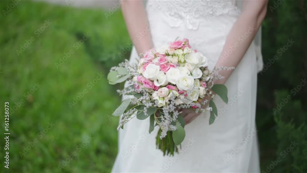 Close up shot of the bride that holds a wedding bouquet in hands. Selective focus. Close up shot of the bride that holds a wedding bouquet in hands. Selective focus.