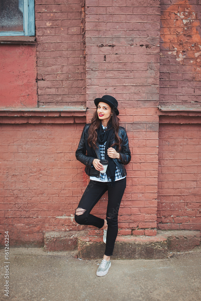 Young stylish woman in a city street drinking coffee Young stylish woman in a city street drinking coffee