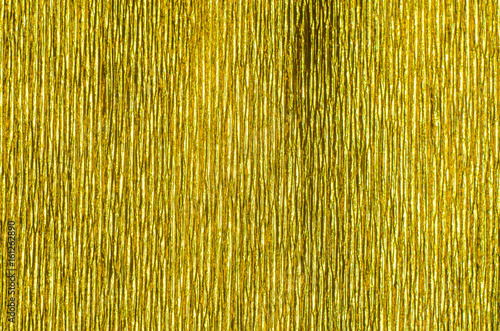 Gold Texture of Embossed Paper. Gold Paper Texture Background. Abstract background with deep grooves in the texture of corrugated paper. Pattern of vertical grooves