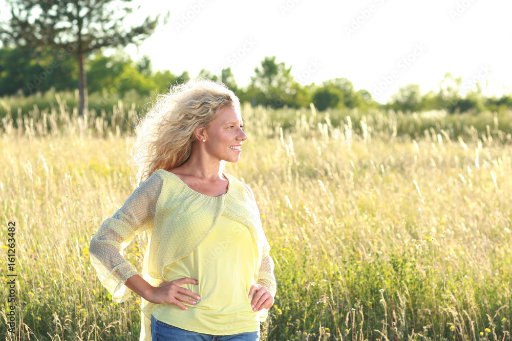 Hübsche Frau mittleren alters in der Natur im Sommer Hübsche Frau mittleren alters in der Natur im Sommer
