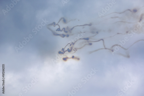 Writing on the sky. Smoke trails from jet fighters on a cloudy sky. Abstract and decorative.