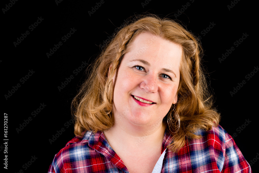 Portrait of a attractive european light overweighted red haired female with red lumberjack shirt - view on head, studio shot in fron of black background Portrait of a attractive european light overweighted red haired female with red lumberjack shirt - view on head, studio shot in fron of black background