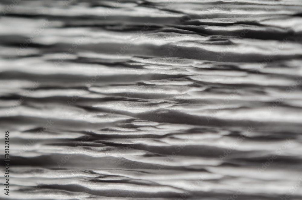 Obraz premium White texture of embossed paper. Macro. Shallow depth of field. Abstract background with deep grooves in the texture of corrugated paper. Pattern of horizontal grooves