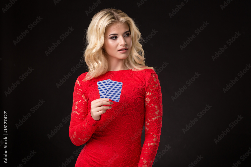 Young beautiful emotional woman with cards in hands on a black background in the studio. Poker Young beautiful emotional woman with cards in hands on a black background in the studio. Poker