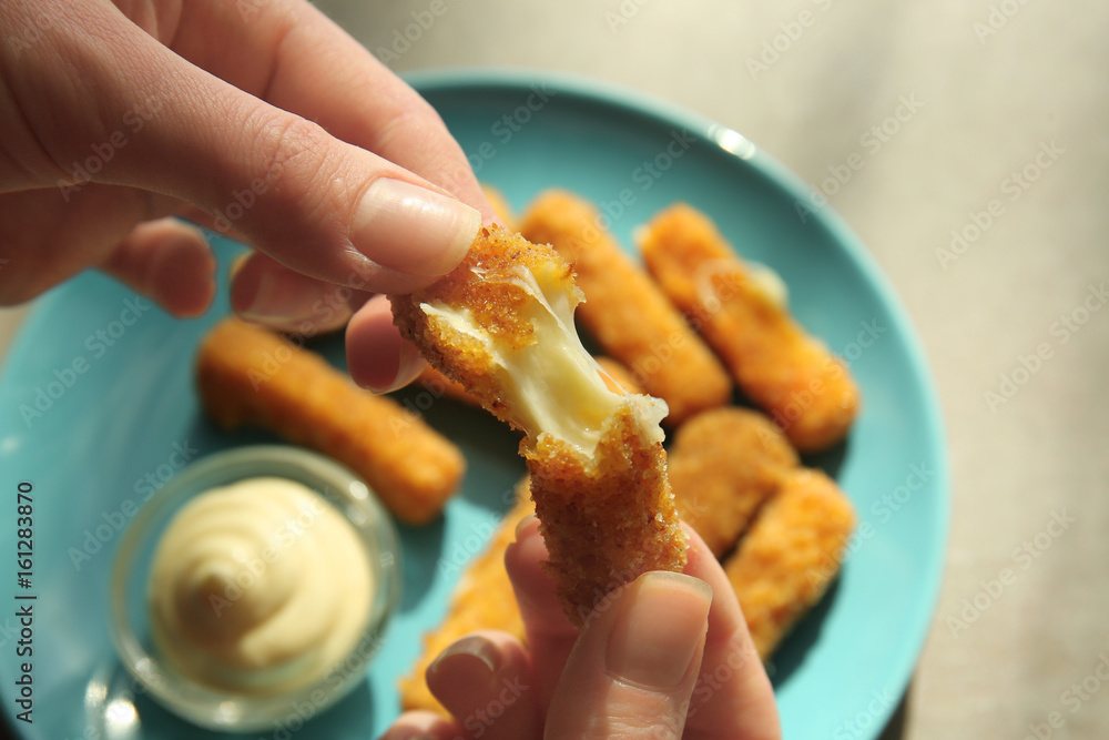 Female hands with cheese stick