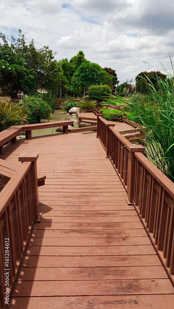 Obraz premium wooden walk way with landscape of garden