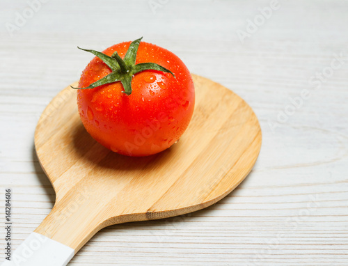 tomato with wooden cutlery on white wooden background photo