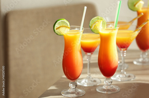 Glasses of Tequila Sunrise cocktail with citrus slices on table