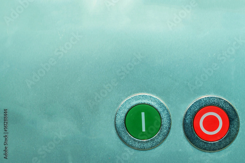 Red and green on and off buttons on metal surface photo