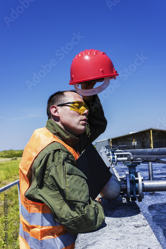 A worker wipes sweat from his face