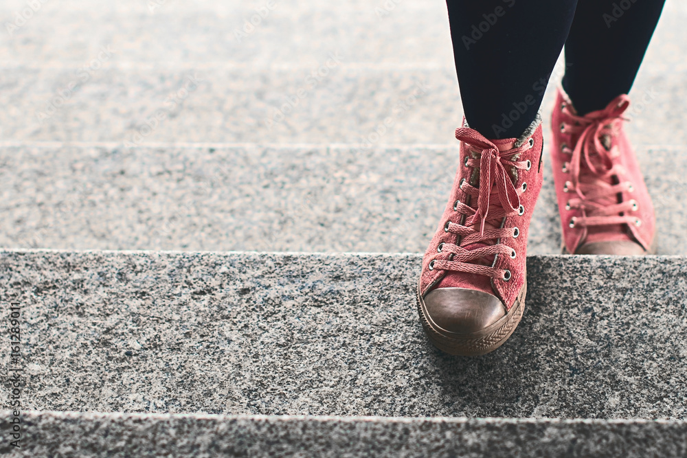 Fototapeta Kobieta iść na piechotę w czarnych leginsach i różowych sneakers wspina się kamiennych schodki plenerowych z kopii przestrzenią