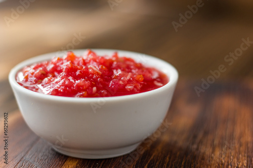 Indian chutney or mexican salsa in white ceramic bowl.
