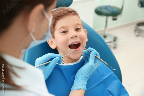 Fototapeta Naklejka Na Ścianę i Meble -  Dentist examining little boy's teeth in clinic