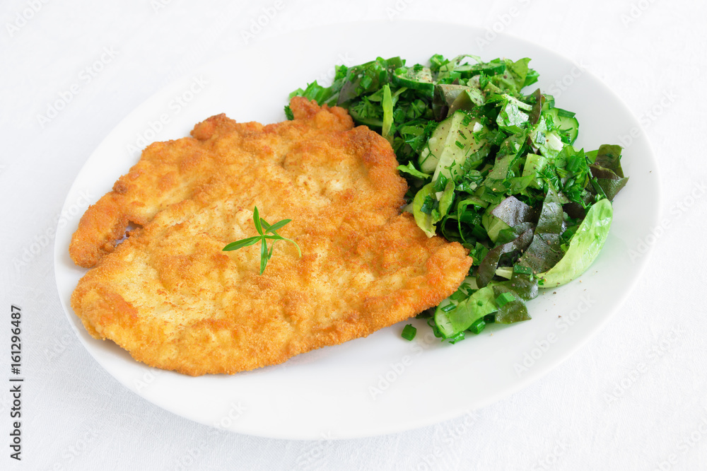 chicken schnitzel with green salad dressed with olive oil and lemon juice