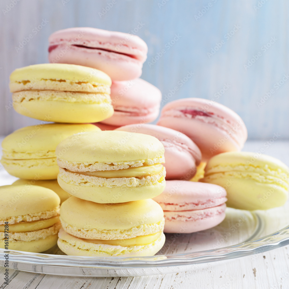 Yellow and pink macaroons on white wooden background. Yellow and pink macaroons on white wooden background.