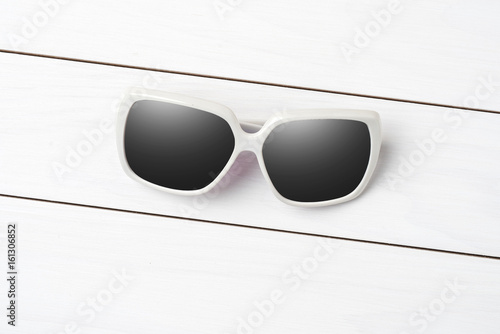 Sunglasses on white wooden table