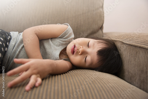 Asian little kid girl sleeping on sofa.