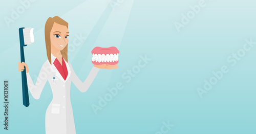 Dentist with a dental jaw model and a toothbrush.