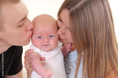 Closeup portrait of beautiful young family with newborn