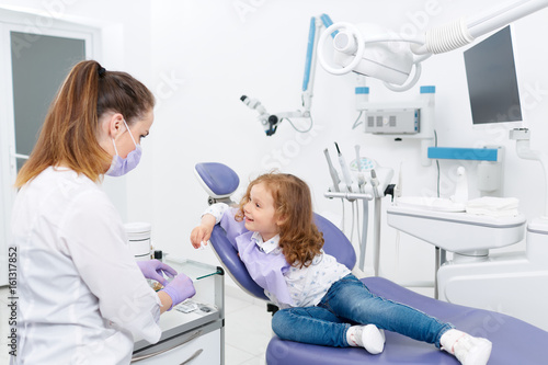 Little patient and dentist in cabinet